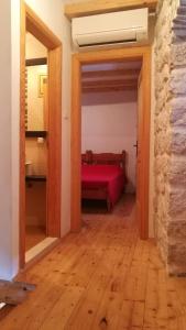 a bedroom with a red bed in a room at Mediterranean stone house Ucović in Gruda