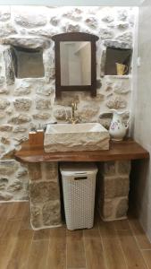 a bathroom with a sink and a stone wall at Mediterranean stone house Ucović in Gruda