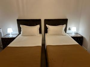 two beds sitting next to each other in a room at Pensiunea Le Patrick in Afumaţi