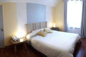 1 dormitorio con 1 cama blanca y ventana en Gîte du Flotteur, en Chevroches