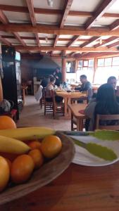 a group of people sitting at tables in a restaurant at Cabañas Santa Maria Huife in Pucón