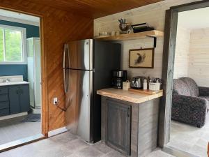 a kitchen with a stainless steel refrigerator in a room at Le Gaston, chalet en campagne 