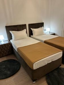 two beds sitting next to each other in a room at Pensiunea Le Patrick in Afumaţi