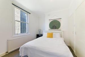 a white bedroom with a white bed and a window at Spacious Maida Vale 2 Bed Apartment in London