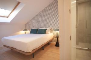 a bedroom with a white bed with blue pillows at Apartment in Chamberi in Madrid