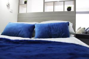 een bed met blauwe en witte kussens in een slaapkamer bij Lovely Studio Flat in Bolton in Bolton