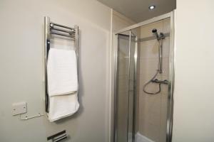 een badkamer met een douche en een handdoekenrek bij Lovely Studio Flat in Bolton in Bolton