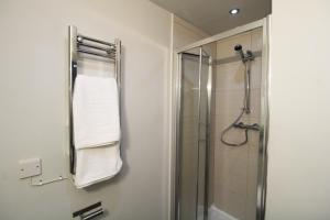 a bathroom with a shower and a towel rack at Lovely Studio Flat in Bolton in Bolton