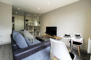 een woonkamer met een bank en een tafel bij Lovely Studio Flat in Bolton in Bolton