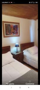 a bedroom with two beds and a table with a lamp at La Ruta del Jazz in Santa Cruz
