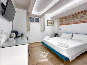 ein kleines Schlafzimmer mit einem Bett und einem TV in der Unterkunft MareMò Accomodations - Rooms in Tropea in Tropea
