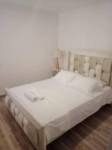 1 cama blanca grande con marco de cama blanco grande en Apartamento 2 habitaciones, en Barranquilla