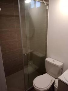 y baño con aseo y ducha acristalada. en Apartamento 2 habitaciones, en Barranquilla
