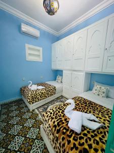 two beds in a room with a leopard print at DAR AL NOUR in Marrakesh