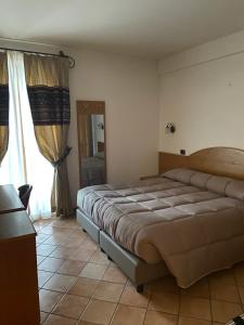 1 dormitorio con 1 cama grande en una habitación en HOTEL MILLE PINI, en Ovindoli