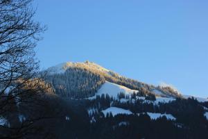 a mountain covered in snow and trees with the sun shining on it at Latina II in Westendorf