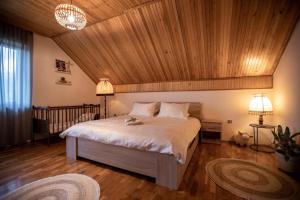 Holiday house On the riverside في أوغولين: غرفة نوم بسرير كبير بسقف خشبي