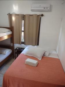 ガロパバにあるFerrugem Pousada Regiãoのベッド1台(タオル2枚付)が備わる客室です。