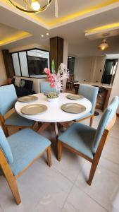 une salle à manger avec une table et des chaises blanches dans l'établissement La Terraza departamentos 401, à Cuenca