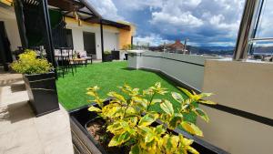 a balcony with grass and plants on a building at La Terraza departamentos 401 in Cuenca
