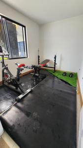 una habitación con un gimnasio con 2 bicicletas y un simulador en La Terraza departamentos 401, en Cuenca