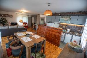 Holiday house On the riverside في أوغولين: مطبخ وغرفة معيشة مع طاولة وكراسي خشبية