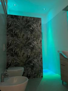 baño con lavabo y pared con luz verde en Appartamento Sant'Andrea en Mesagne