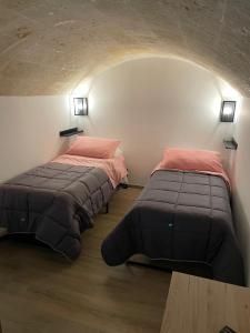 2 camas sentadas en una habitación con arco en Appartamento Sant'Andrea en Mesagne