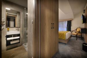 ein Bad mit einer Dusche und ein Schlafzimmer mit einem Bett in der Unterkunft Vysocina Design Apartments in Hlinsko