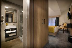 łazienka z prysznicem oraz sypialnia z łóżkiem w obiekcie Vysocina Design Apartments w mieście Hlinsko +37 zdjęć
