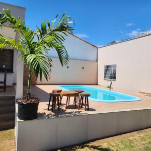 patio ze stołem i krzesłami przy basenie w obiekcie Casa de Praia - Guriri w mieście São Mateus