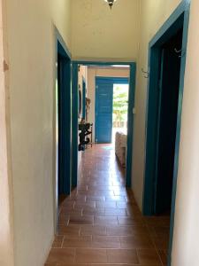 - un couloir avec des portes bleues et du carrelage dans l'établissement Sítio Santo Antônio, à Socorro