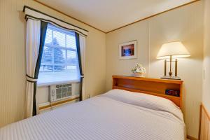 1 dormitorio con cama blanca y ventana en Cozy Lakemont Getaway, 11 Mi to Watkins Glen!, 