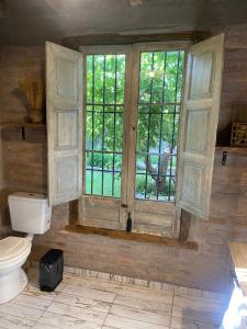 a bathroom with a toilet and a window at Casa Terra in Ciudad Lujan de Cuyo +10 photos