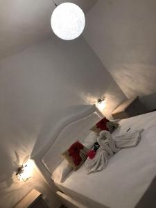 a bedroom with a bed with white sheets and red pillows at Affittacamere Valentina in Verona