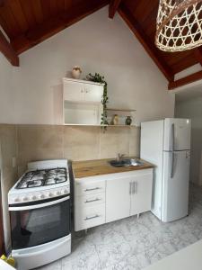 a kitchen with a stove and a white refrigerator at Apartamento Remansum in Santa Rosa de Calamuchita