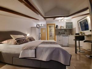a bedroom with a large bed and a kitchen at Apartments Prpić 1,Senj in Senj
