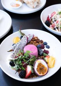a plate of food with fruit on a table at Luxury inner-west flat w/ breakfast and coffee included! in Sydney
