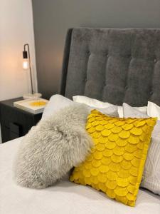 a stuffed animal laying on a bed next to a yellow pillow at Luxury inner-west flat w/ breakfast and coffee included! in Sydney