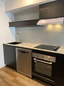 a kitchen with a sink and a stove at Luxury inner-west flat w/ breakfast and coffee included! in Sydney