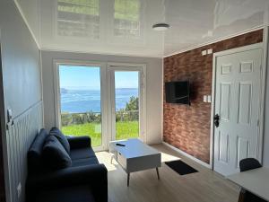 a living room with a couch and a view of the ocean at Acogedora Casa de Paz in Dalcahue