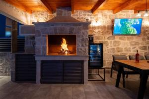a stone fireplace in a living room with a table at Adam apartments in Stobreč