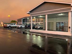 a parking lot with cars parked in front of a store at Budget Inn - Saint Robert in Saint Robert