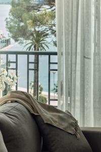 a person laying on a couch looking out a window at La Fleur Boutique Hotel in Tivat