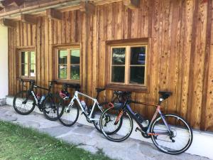 drei Fahrräder, die außerhalb eines Holzgebäudes geparkt sind in der Unterkunft Klösterle Haus Resi in Arriach