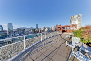 a balcony with two white chairs and a building at loft in downtown Vancouver with free parking in Vancouver