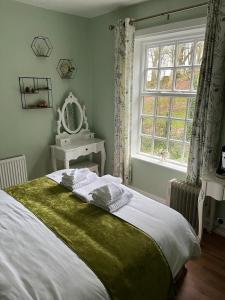 The Old Postie Bed & Breakfast في Annesley: غرفة نوم بسرير كبير ونافذة