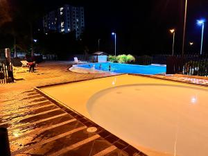 una piscina vacía por la noche con gente alrededor en Apartamento en Pereira, en Pereira