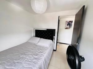 1 dormitorio pequeño con 1 cama y ventilador en Apartamento en Pereira, en Pereira