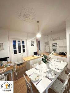 uma cozinha e sala de jantar com mesa e cadeiras em Ulyssee Seh’Loué em Saint-Brieuc